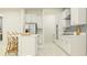 Modern kitchen features white cabinetry, stainless steel appliances, and center island with bar stools at 12054 Violet Jasper Dr, Parrish, FL 34219