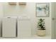 Bright laundry area equipped with washer, dryer, overhead storage, and decorative plant at 12054 Violet Jasper Dr, Parrish, FL 34219