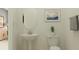 Chic half-bathroom featuring a pedestal sink, toilet, modern decor, and minimalist design at 12062 Violet Jasper Dr, Parrish, FL 34219