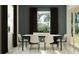 Modern dining room with sleek furniture, black curtains, and a large window at 12062 Violet Jasper Dr, Parrish, FL 34219