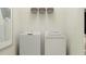 Neat laundry room with a washer, dryer, storage shelf, and neutral decor at 12062 Violet Jasper Dr, Parrish, FL 34219