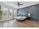 Modern bedroom features a statement wall and a four-poster bed, complemented by sleek, black nightstands and light-filled windows at 121 E Warren Ave # 1, Tampa, FL 33602