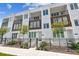 Modern townhome exterior with white facade, wood accents, balconies, and a black iron fence at 121 E Warren Ave # 1, Tampa, FL 33602
