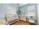 Cozy Bedroom with a crib, dresser, and ocean themed decorations to foster a soothing atmosphere at 13414 Graham Yarden Dr, Riverview, FL 33579