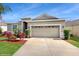 Inviting one-story home with a two-car garage and freshly landscaped front yard under a clear blue sky at 13414 Graham Yarden Dr, Riverview, FL 33579