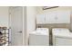 Efficient laundry room featuring front load washer, dryer and ample upper cabinet storage space at 13414 Graham Yarden Dr, Riverview, FL 33579