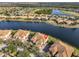 Stunning aerial view of the lakefront property with lush landscaping and tile roof at 1348 Emerald Dunes Dr, Sun City Center, FL 33573