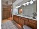 Bathroom featuring a double vanity, granite countertops, and a walk-in glass shower at 1348 Emerald Dunes Dr, Sun City Center, FL 33573