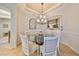 Elegant dining area with a glass table, chandelier, and coastal-themed decor, bathed in natural light at 1348 Emerald Dunes Dr, Sun City Center, FL 33573