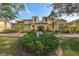 Inviting exterior view of the condo featuring lush landscaping and a covered entryway at 1348 Emerald Dunes Dr, Sun City Center, FL 33573