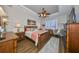 Comfortable main bedroom with a ceiling fan, tray ceiling, and ample natural light from a large window at 1348 Emerald Dunes Dr, Sun City Center, FL 33573