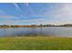 Picturesque view of a serene lake with lush green grass and beautiful homes in the background at 1348 Emerald Dunes Dr, Sun City Center, FL 33573