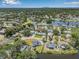 Expansive aerial view showcases the property's location near a lake, with mature trees and neighborhood surroundings at 1404 84Th N Ave, St Petersburg, FL 33702