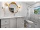 Stylish bathroom featuring white marble walls, patterned floor tiles and an elegant round gold mirror at 1404 84Th N Ave, St Petersburg, FL 33702