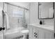 Stylish bathroom with a shower over bath, granite counters, and a modern mirror at 1404 84Th N Ave, St Petersburg, FL 33702