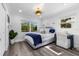 Cozy bedroom with hardwood floors, two windows, and a decorative blue-patterned bed frame at 1404 84Th N Ave, St Petersburg, FL 33702
