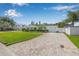 Charming single-story home with lush green lawn, manicured hedges, and a paved driveway leading to a garage at 1404 84Th N Ave, St Petersburg, FL 33702