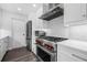 A well-equipped kitchen with stainless steel stove, appliances, white cabinets, and modern backsplash at 1404 84Th N Ave, St Petersburg, FL 33702