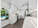 A bright kitchen with white cabinets, stainless steel appliances, and a view to the backyard pool at 1404 84Th N Ave, St Petersburg, FL 33702