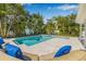 This backyard features a stunning pool, spa, stone pavers, and lounge chairs for relaxation at 1404 84Th N Ave, St Petersburg, FL 33702