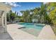 An inviting private pool and spa are surrounded by lush landscaping and a stone paver deck at 1404 84Th N Ave, St Petersburg, FL 33702