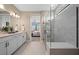 Well-lit bathroom featuring a double vanity, modern lighting, and a glass-enclosed walk-in shower at 16419 Sapphire Point Dr, Lakewood Ranch, FL 34211