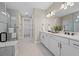 Bright bathroom with a double vanity, modern lighting, and a glass enclosed tub shower at 16419 Sapphire Point Dr, Lakewood Ranch, FL 34211