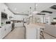 Open-concept kitchen featuring white cabinetry, stainless steel appliances, and a large center island with seating at 16419 Sapphire Point Dr, Lakewood Ranch, FL 34211