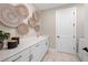 Well-lit laundry room features white cabinetry, quartz countertops, sink, and decorative woven baskets on the wall at 16419 Sapphire Point Dr, Lakewood Ranch, FL 34211