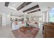 Bright living room featuring wood beam ceiling, tile floors, stylish rug, and open floor plan at 16419 Sapphire Point Dr, Lakewood Ranch, FL 34211