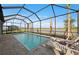 Screened-in pool features a lake view, lounge chairs, and palm trees, creating a serene outdoor space at 16419 Sapphire Point Dr, Lakewood Ranch, FL 34211