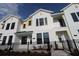 A charming row of townhouses featuring bright exteriors, dark trim windows and well-kept landscaping at 1643 Springwell Ln, Sarasota, FL 34240