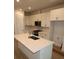 Modern kitchen features white cabinets, stone countertops, and a stainless steel microwave at 1643 Springwell Ln, Sarasota, FL 34240