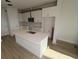 Bright kitchen with white cabinets, a large island with sink, and stainless steel microwave at 1643 Springwell Ln, Sarasota, FL 34240