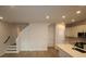 Open living area with stairs, light wood floors, and kitchen with white cabinets and countertops at 1643 Springwell Ln, Sarasota, FL 34240