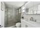 Bathroom features glass shower with gray tiling, plus modern sink, and a large mirror at 1812 Teakwood Ln, Dunedin, FL 34698
