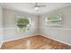 Well-lit bedroom with hardwood floors and two windows providing ample natural light at 1812 Teakwood Ln, Dunedin, FL 34698
