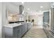 Spacious kitchen featuring gray cabinetry, an island with bar seating, and hardwood flooring at 1812 Teakwood Ln, Dunedin, FL 34698