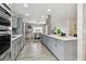 Modern kitchen with stainless steel appliances, quartz countertops, and a view into the dining area at 1812 Teakwood Ln, Dunedin, FL 34698