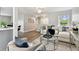 Spacious living room with hardwood floors, a ceiling fan, and a seamless transition to the dining area at 1812 Teakwood Ln, Dunedin, FL 34698