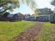 Spacious backyard featuring a tiki hut with bar, picnic table, and lush landscaping at 1818 Douglas Ave, Dunedin, FL 34698