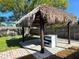 Charming backyard featuring a tiki hut, bar, and a picnic table, creating a fun outdoor space at 1818 Douglas Ave, Dunedin, FL 34698