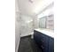 Modern bathroom featuring a double vanity, tiled floors, and a glass-enclosed shower with marble-look surround at 1818 Douglas Ave, Dunedin, FL 34698