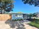 Charming blue single-story home with manicured lawn, front walkway and a lush landscape at 1818 Douglas Ave, Dunedin, FL 34698