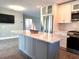 Renovated kitchen with island, stainless appliances, and white cabinets at 1818 Douglas Ave, Dunedin, FL 34698
