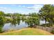 Backyard showing lake view, wooden fence, and green lawn at 18408 Hanna Rd, Lutz, FL 33549