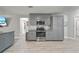 Modern kitchen featuring gray cabinets, granite countertops, and stainless steel appliances at 18408 Hanna Rd, Lutz, FL 33549