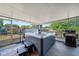 Enclosed patio featuring a hot tub, outdoor grill, and scenic backyard views at 18408 Hanna Rd, Lutz, FL 33549