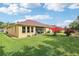 Manicured backyard with lush green lawn, mature landscaping, screened lanai, and ample space for outdoor activities at 20254 Ravens End Dr, Tampa, FL 33647