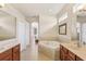 Bright bathroom with dual sinks, a large tub, and a doorway to the bedroom at 20254 Ravens End Dr, Tampa, FL 33647